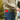 Close-up of a child with a skateboard and a red Xplora phone in their jeans pocket.